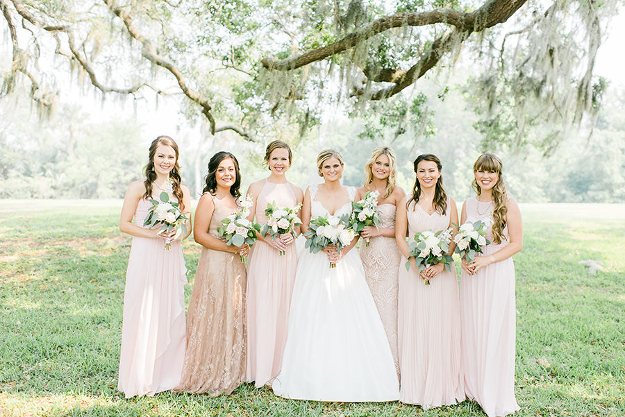 Neutral colored bridesmaids dresses posing outside the Ribault Club
