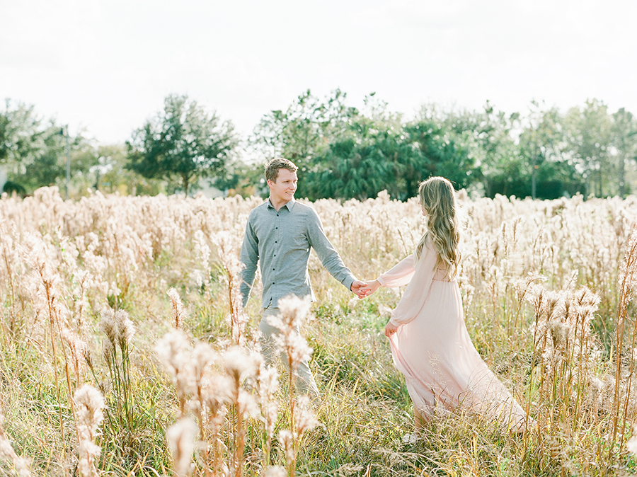 couple walking through tall grass